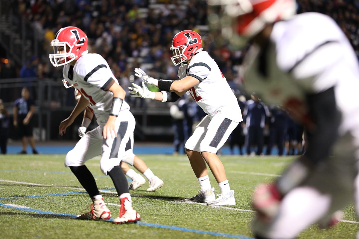 Taking the snap as the QB Lancaster player trying to shake off a Depew Defender Lancaster Legends Football 10.13.17 Lancaster vs Depew