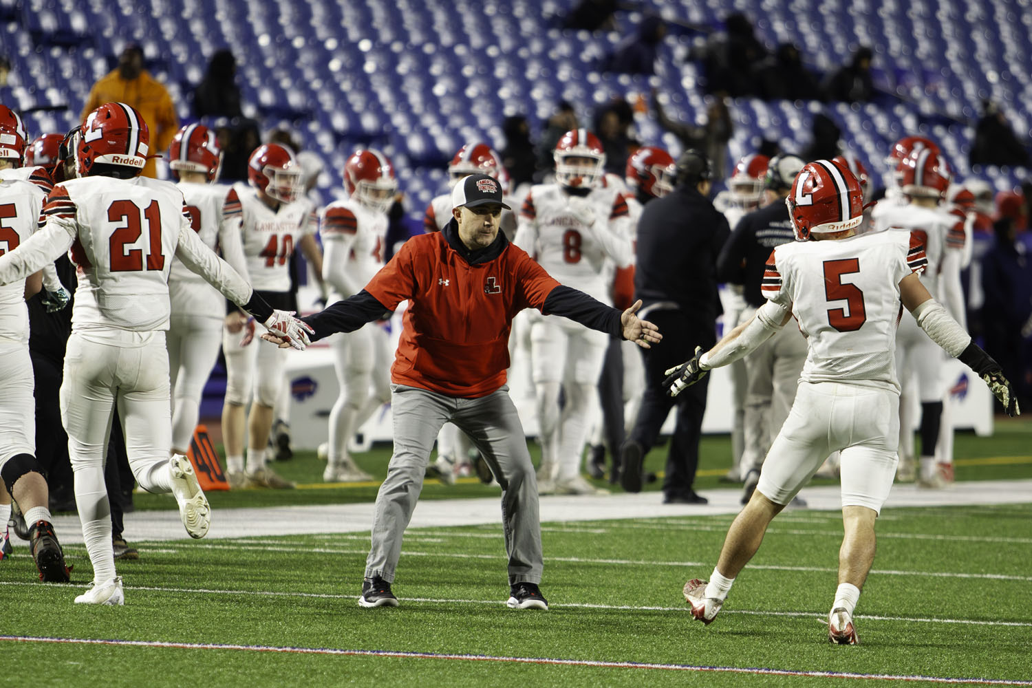 Coach celebrating with Legend players coming off the field