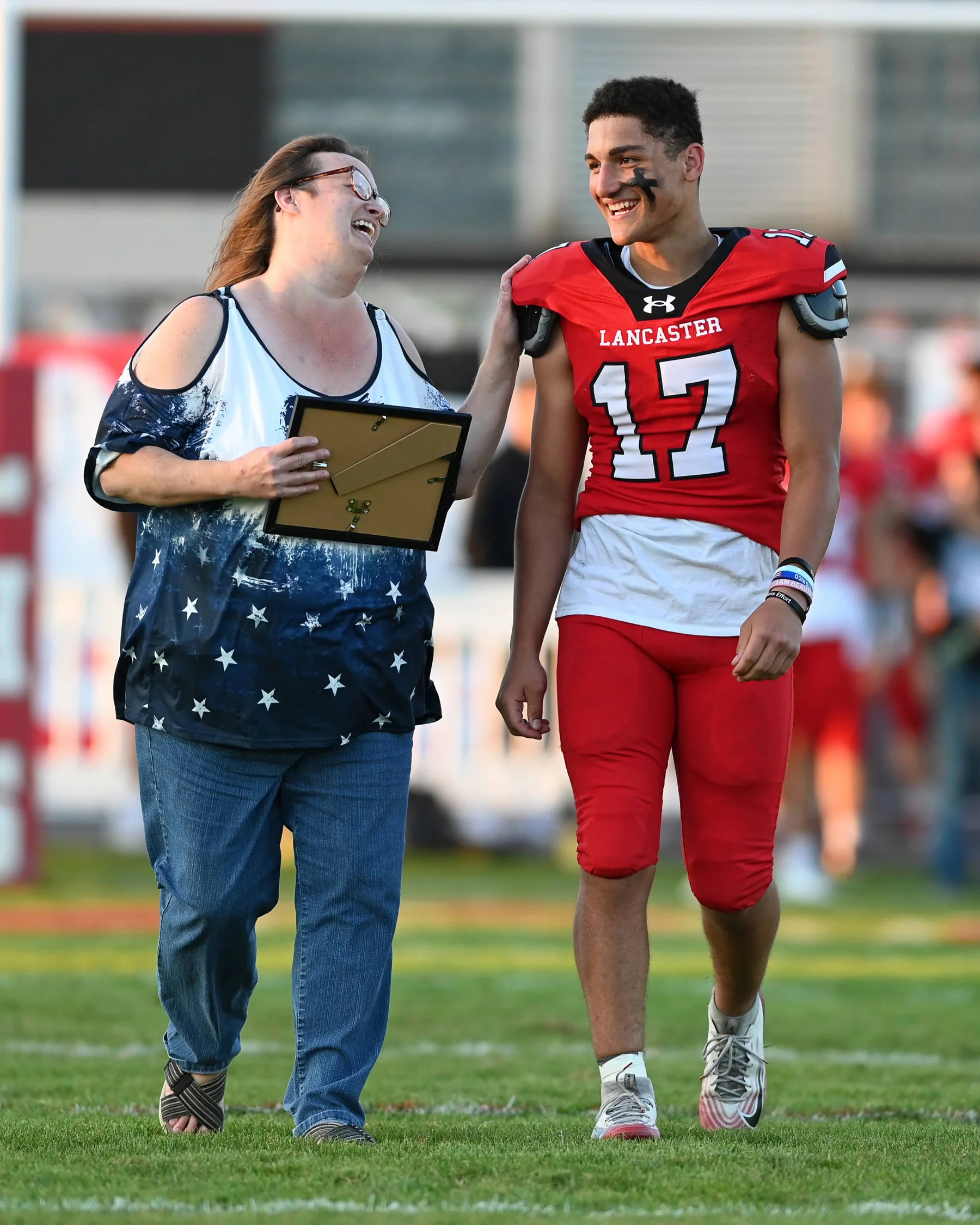 Michael talking to the teacher as they walk onto the field