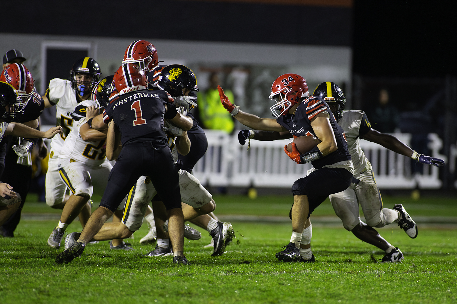 Lancaster RB stiff arms to the hole